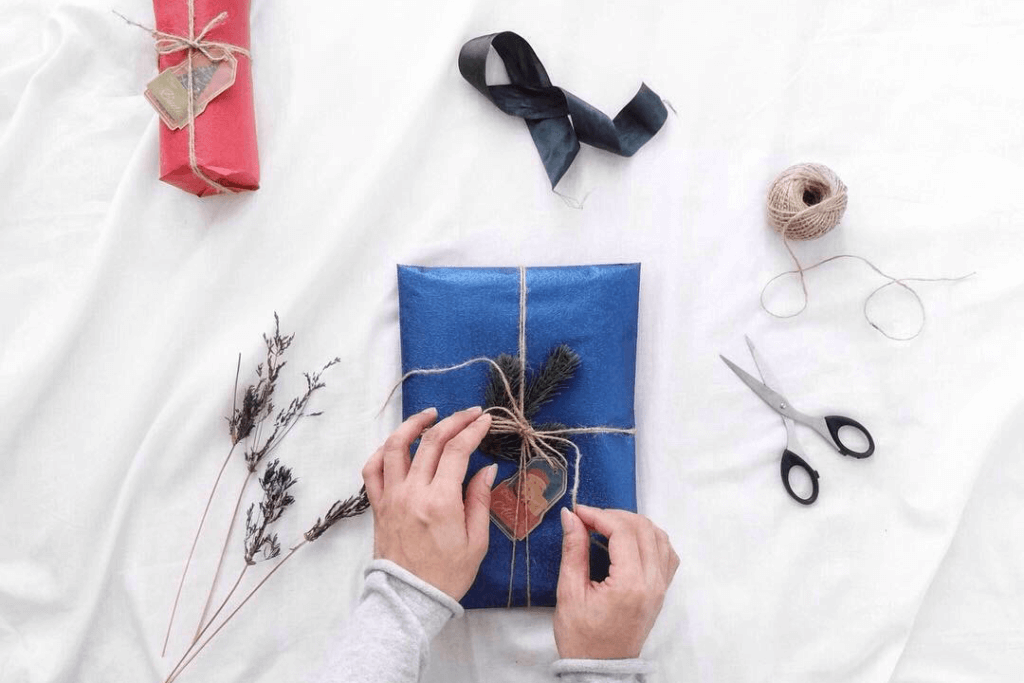 Hands wrapping corporate holiday gifts