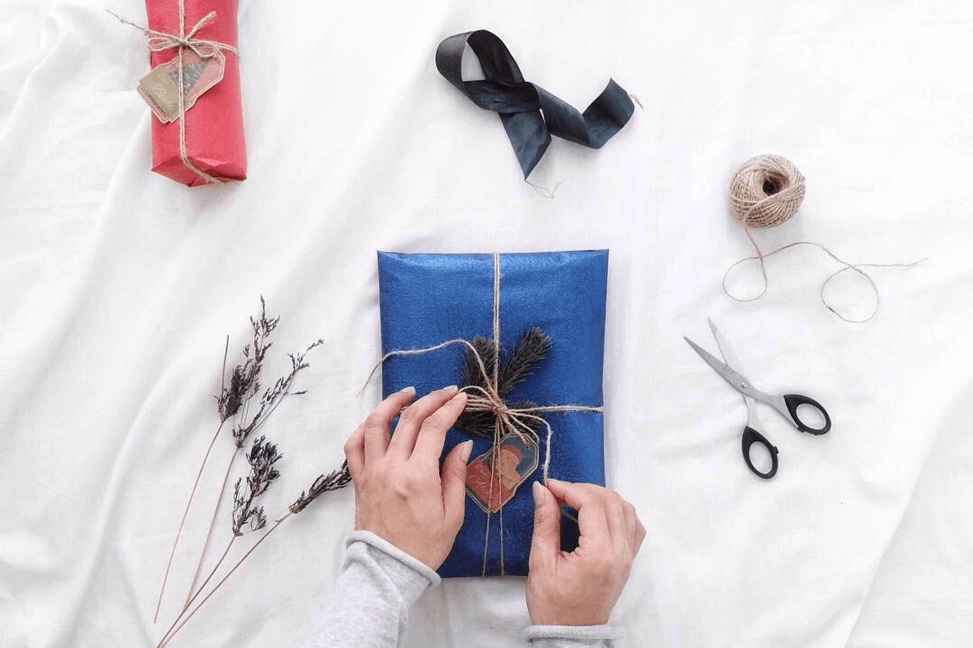 Hands wrapping corporate holiday gifts