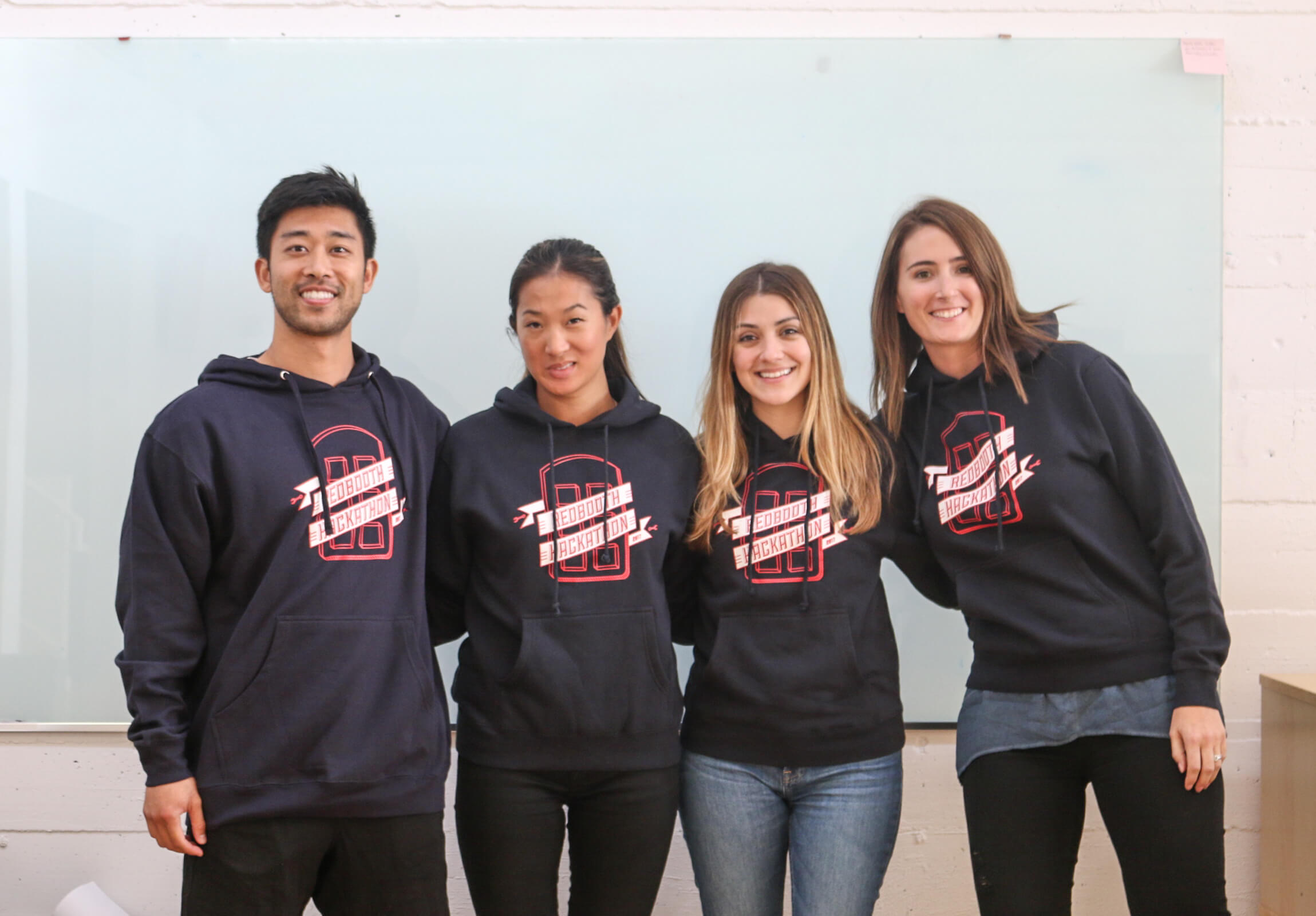 Redbooth hackathon participants pose with hoodies