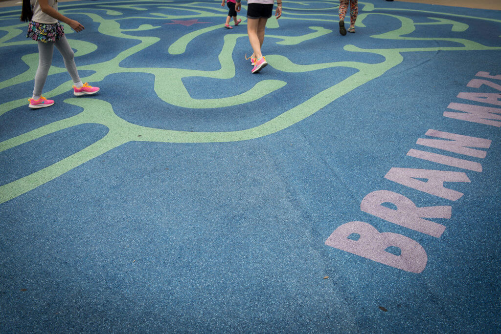 feet running through maze painted on concrete
