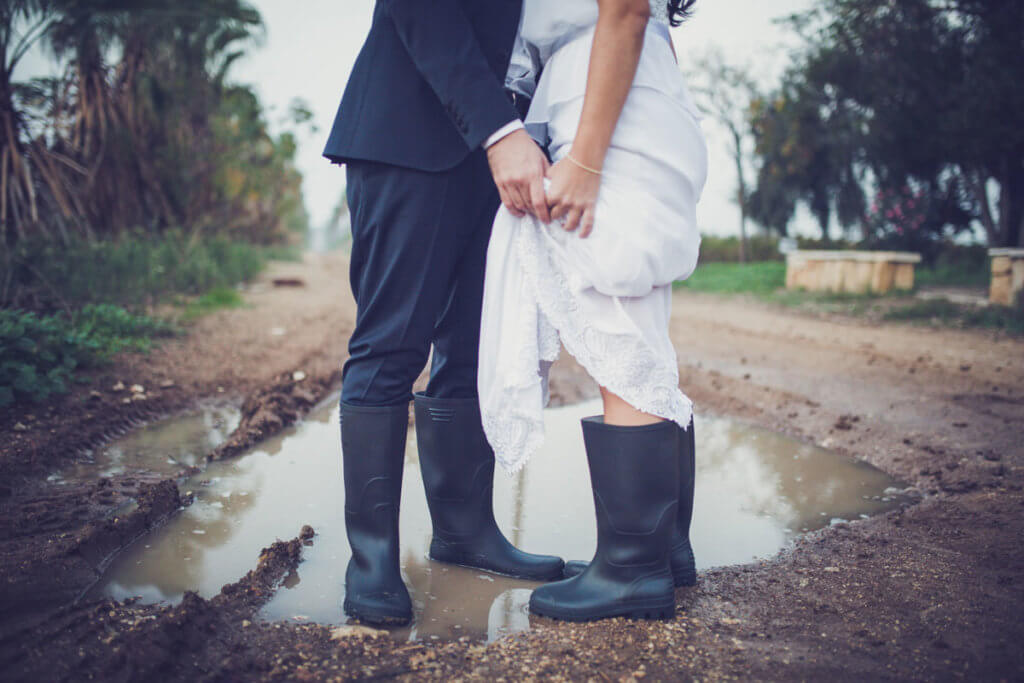bride and groom in rainboots and puddle